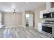 Open kitchen and dining area with stainless steel appliances, white cabinetry, and vinyl floors at 9733 E Baywood Ave, Mesa, AZ 85208