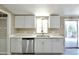 Bright kitchen with white cabinets, stainless steel dishwasher, and granite countertops at 9733 E Baywood Ave, Mesa, AZ 85208