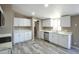 Kitchen with white cabinets, stainless steel appliances, and laminate wood flooring at 9733 E Baywood Ave, Mesa, AZ 85208