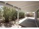 Covered patio with concrete pad, shrubbery, and gravel surround offers a relaxing outdoor space at 9733 E Baywood Ave, Mesa, AZ 85208