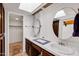 Well-lit bathroom features dual sinks, ample countertop space, and a convenient walk-in closet at 1023 E Sahuaro Dr, Phoenix, AZ 85020