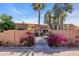 Front exterior view showcasing a gated entrance and vibrant flowering bougainvillea at 1023 E Sahuaro Dr, Phoenix, AZ 85020