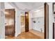 Hallway with bathroom and utility closet featuring tile flooring and convenient washer/dryer hookups at 1023 E Sahuaro Dr, Phoenix, AZ 85020
