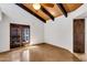 Bright living room featuring exposed wood beam ceilings, ceiling fan, and glass doors to the outside at 1023 E Sahuaro Dr, Phoenix, AZ 85020