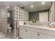 Bathroom featuring marble double vanity, custom mirror and glass block partition at 106 E Echo Ln, Phoenix, AZ 85020