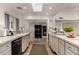 Bright kitchen with skylight, featuring marble countertops, stainless steel appliances, and modern design at 106 E Echo Ln, Phoenix, AZ 85020