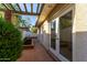 Enclosed brick patio with pergola, garden bed, and door into home at 106 E Echo Ln, Phoenix, AZ 85020