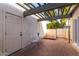 Cozy brick patio with white chairs, table, and shaded pergola at 106 E Echo Ln, Phoenix, AZ 85020