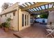 Spacious brick patio with a pergola, perfect for outdoor dining and relaxation with a view of the garden and pool at 106 E Echo Ln, Phoenix, AZ 85020