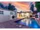 Inviting backyard pool with a fountain, surrounded by a brick patio and lush landscaping, ideal for outdoor living at 106 E Echo Ln, Phoenix, AZ 85020