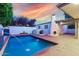 Backyard pool featuring brick surround, a pergola, and an outdoor fireplace at 106 E Echo Ln, Phoenix, AZ 85020