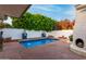 Private pool area featuring a custom outdoor fireplace, perfect for relaxing and entertaining by the water at 106 E Echo Ln, Phoenix, AZ 85020