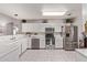 Well-lit kitchen featuring stainless steel appliances, white cabinetry, and tile floors at 10937 N Ventana W Dr, Peoria, AZ 85373