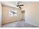 Bedroom includes neutral carpet, ceiling fan, closet, and window at 1202 W Wickieup Ln, Phoenix, AZ 85027