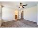Bedroom boasts an open arched bathroom entrance, neutral carpet, and a ceiling fan at 1202 W Wickieup Ln, Phoenix, AZ 85027