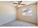 Carpeted bedroom featuring a ceiling fan, natural light, and closet space at 1202 W Wickieup Ln, Phoenix, AZ 85027