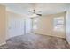 Bedroom featuring a ceiling fan, carpet flooring, and a closet with white doors at 1202 W Wickieup Ln, Phoenix, AZ 85027