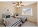 Bright bedroom showcasing two twin beds, neutral walls, and a ceiling fan, perfect for  at 1202 W Wickieup Ln, Phoenix, AZ 85027