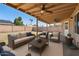 Covered patio with outdoor seating and fan overlooking a backyard perfect for entertaining or relaxing at 1202 W Wickieup Ln, Phoenix, AZ 85027