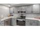 Updated kitchen with stainless steel appliances, gray cabinets, and sleek countertops at 12212 N Paradise Vlg S Pkwy # 113, Phoenix, AZ 85032