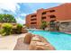Outdoor pool with rock waterfall and lounge chairs at 12212 N Paradise Vlg S Pkwy # 113, Phoenix, AZ 85032