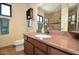 Single sink bathroom with brown cabinets, tile floors and walk-in shower in the mirror at 12965 N 95Th Way, Scottsdale, AZ 85260
