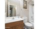 Bathroom vanity and sink with framed mirror, shower over tub, and toilet at 13723 W Rovey Ave, Litchfield Park, AZ 85340