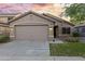 Charming single-story home with a two-car garage, desert landscaping, and a beautiful sunset sky at 13723 W Rovey Ave, Litchfield Park, AZ 85340