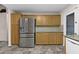 Spacious kitchen with stainless steel fridge, wood cabinets and granite countertops at 13723 W Rovey Ave, Litchfield Park, AZ 85340