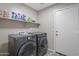 This spacious laundry room has modern appliances, a built-in shelf, and a neutral color palette at 13723 W Rovey Ave, Litchfield Park, AZ 85340