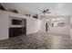 Bright living room with decorative fireplace, a TV, tiled flooring, and an open view to the kitchen at 13723 W Rovey Ave, Litchfield Park, AZ 85340