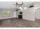 Open living area with decorative fireplace, ceiling fan, and a view to the house entrance at 13723 W Rovey Ave, Litchfield Park, AZ 85340