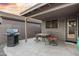 Covered patio with BBQ, dining table, and orange cushions at 13723 W Rovey Ave, Litchfield Park, AZ 85340