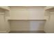 Bright walk-in closet with wooden railing and ample shelving for organization at 13723 W Rovey Ave, Litchfield Park, AZ 85340