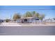 View of a light grey single-story house, street view, fenced yard, mature trees at 1410 S 24Th Ave, Phoenix, AZ 85009