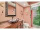 Bathroom with custom sink, mirror, and shower with tile surround at 1473 Leisure World --, Mesa, AZ 85206