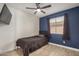 Bright bedroom with a ceiling fan, wood-look flooring, and large window with curtains at 15339 N 148Th Ct, Surprise, AZ 85379
