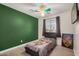 Bedroom with a colorful ceiling fan and accent wall at 15339 N 148Th Ct, Surprise, AZ 85379