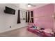 Pink-themed bedroom with a wooden bed, ceiling fan and view from the window at 15339 N 148Th Ct, Surprise, AZ 85379