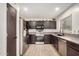 Modern kitchen with stainless steel appliances, dark cabinets, and tile flooring at 15339 N 148Th Ct, Surprise, AZ 85379