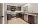 Well-lit kitchen boasts stainless steel appliances, brown cabinetry, and view from window at 15339 N 148Th Ct, Surprise, AZ 85379