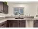 Modern kitchen features gray countertops, stainless steel dishwasher, and view from the window at 15339 N 148Th Ct, Surprise, AZ 85379