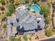 Aerial view of a property with grey tiled roofing, a pool, jacuzzi, and lush landscaping at 15427 E Firerock Country Club Dr, Fountain Hills, AZ 85268
