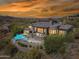 Aerial view of a luxury home with a pool, spa, and desert views at sunset at 15427 E Firerock Country Club Dr, Fountain Hills, AZ 85268