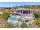 Backyard aerial view of home with a pool, hot tub, lounging patio, and surrounding desert foliage at 15427 E Firerock Country Club Dr, Fountain Hills, AZ 85268