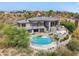 Aerial view of a pool, hot tub, lounging area, and the rear of a home surrounded by desert foliage at 15427 E Firerock Country Club Dr, Fountain Hills, AZ 85268