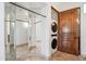 This laundry room has mirrored walls and a stacked washer and dryer for convenience at 15427 E Firerock Country Club Dr, Fountain Hills, AZ 85268