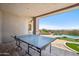 Covered patio features a ping pong table with views of the pool, putting green, and desert landscape at 15427 E Firerock Country Club Dr, Fountain Hills, AZ 85268