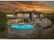 A luxurious home featuring an in-ground pool, spa, and upper and lower outdoor patios at twilight at 15427 E Firerock Country Club Dr, Fountain Hills, AZ 85268