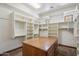 Spacious walk-in closet with custom shelving, center island, and natural light from two windows at 15427 E Firerock Country Club Dr, Fountain Hills, AZ 85268
